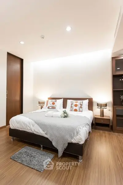 Modern bedroom with cozy lighting and stylish decor, featuring a comfortable bed and wooden flooring.
