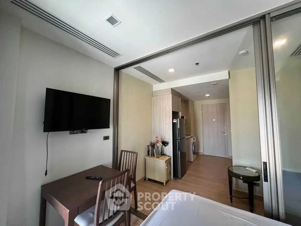 Modern studio apartment with open layout, featuring a compact kitchen and cozy living area.