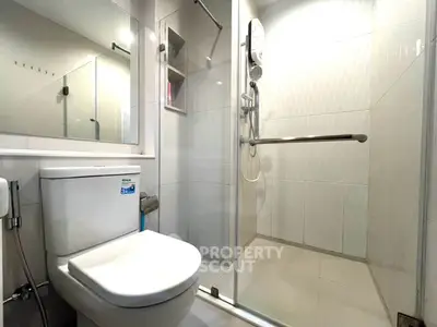 Modern bathroom with glass shower and sleek fixtures in contemporary apartment.