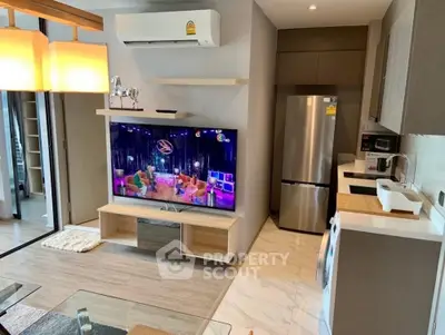 Modern living room with open kitchen, featuring sleek appliances and stylish decor.