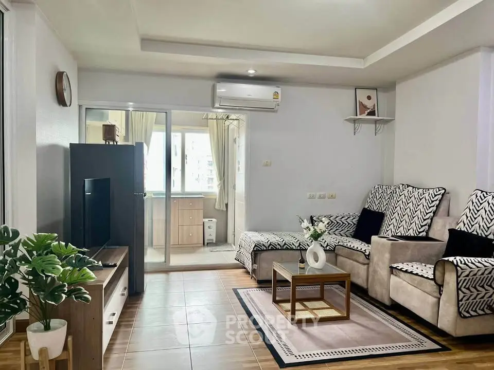 Modern living room with stylish decor and open kitchen view, featuring cozy seating and natural light.