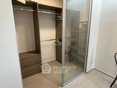 Spacious walk-in closet with sliding glass doors and wooden shelving