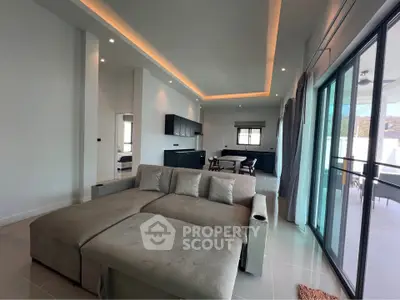Spacious modern living room with large sofa and open layout, featuring sleek design and ample natural light.