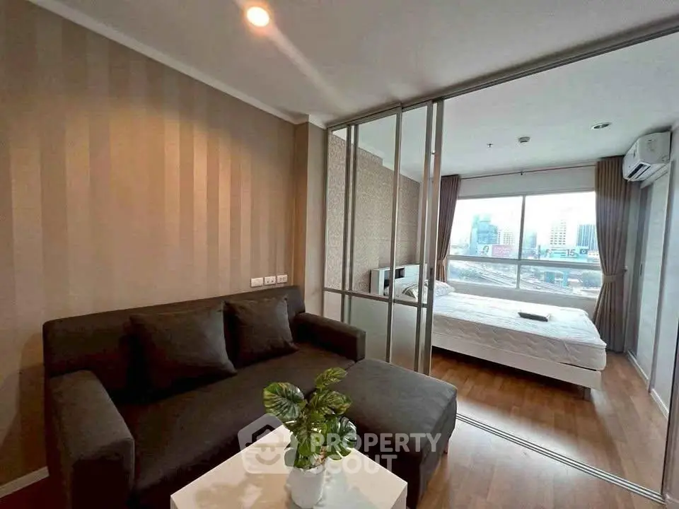 Modern apartment with cozy living room and bedroom, featuring large windows and city view.