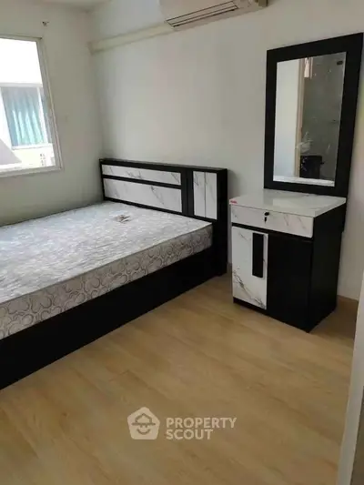 Modern bedroom with stylish bed and dresser, featuring sleek design and ample natural light.