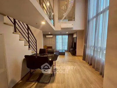 Spacious modern living room with high ceilings and elegant decor in a duplex apartment.