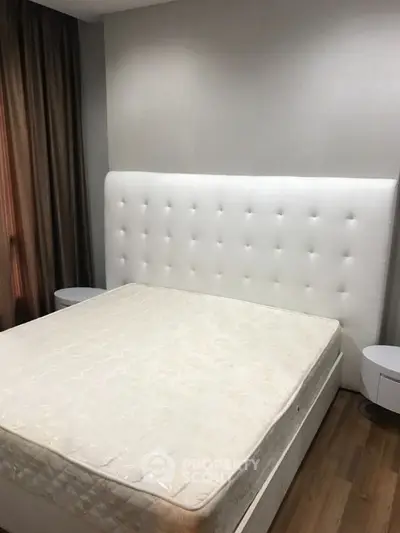 Spacious bedroom with modern white bed and elegant side tables, perfect for comfort and style.
