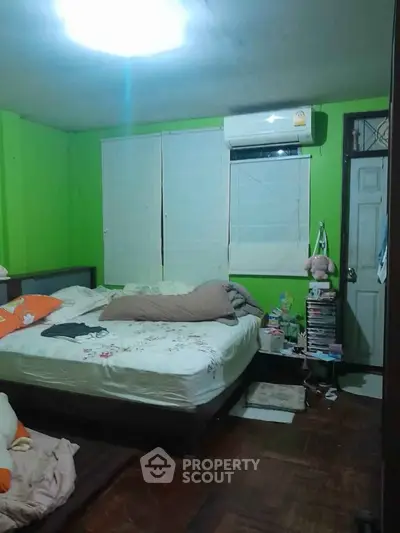 Cozy bedroom with bright green walls and air conditioning unit