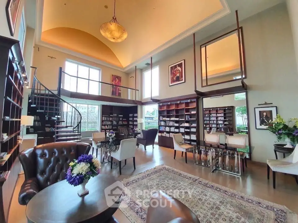 Luxurious library with high ceilings, elegant seating, and spiral staircase in upscale real estate property.