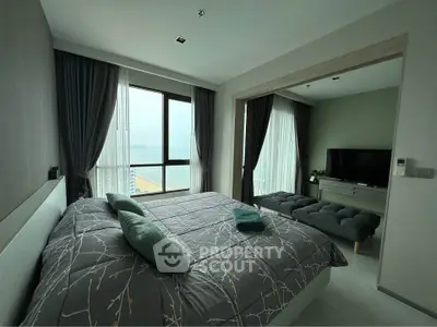 Luxurious bedroom with stunning ocean view and modern decor.