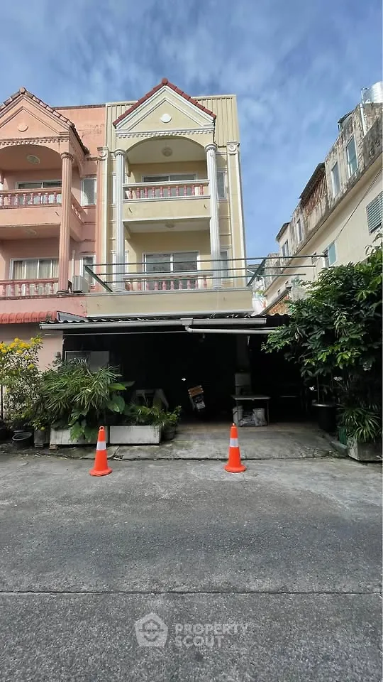 Charming multi-story residential building with classic architecture and lush greenery.