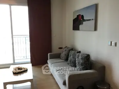 Cozy living room with modern sofa and abstract art, bright natural light from balcony.