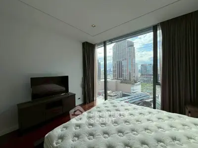 Luxurious bedroom with stunning city view and modern furnishings in high-rise apartment.