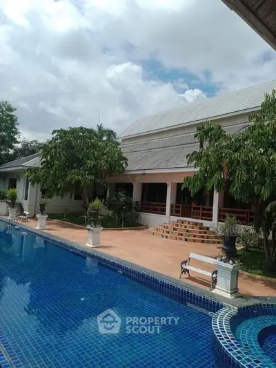 Luxurious property with stunning pool and lush greenery, perfect for relaxation and entertainment.