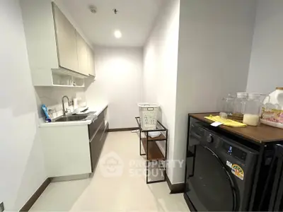 Modern kitchen with sleek cabinetry and washing machine in compact layout.
