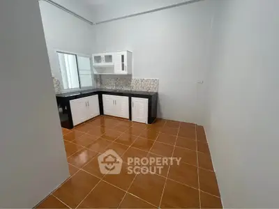 Spacious kitchen with tiled floor and modern cabinetry in a bright, open layout.