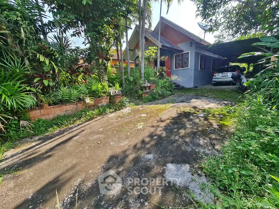 Charming single-story house with lush garden and carport in tranquil setting.