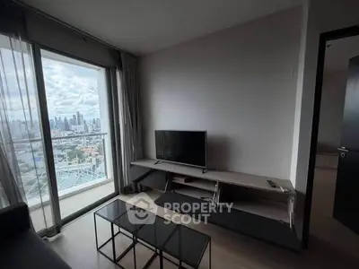 Modern living room with city view, featuring sleek furniture and large windows for natural light.
