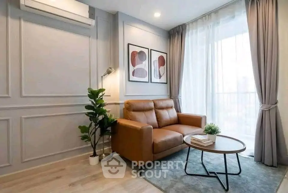 Stylish living room with leather sofa, modern decor, and natural light.