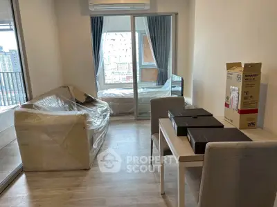 Modern living room with balcony view, featuring sleek furniture and air conditioning, perfect for urban living.