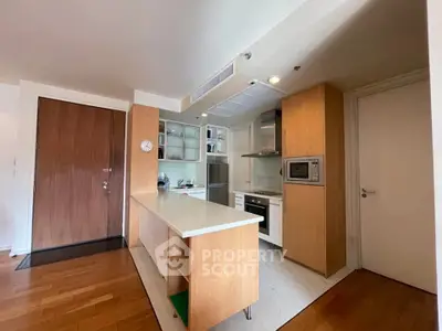 Modern kitchen with wooden cabinetry and sleek appliances in a stylish apartment.