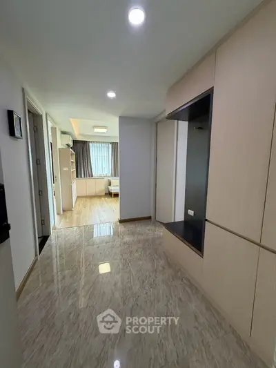 Spacious hallway leading to a bright living area with modern finishes and ample natural light.