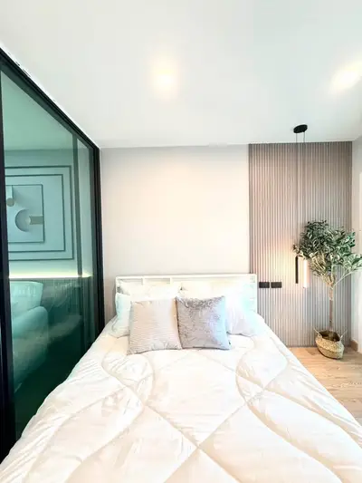 Modern bedroom with stylish decor and cozy bedding in a contemporary apartment.