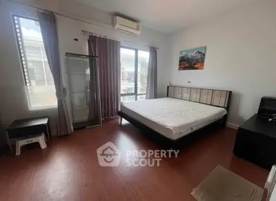 Spacious bedroom with large window and modern furnishings