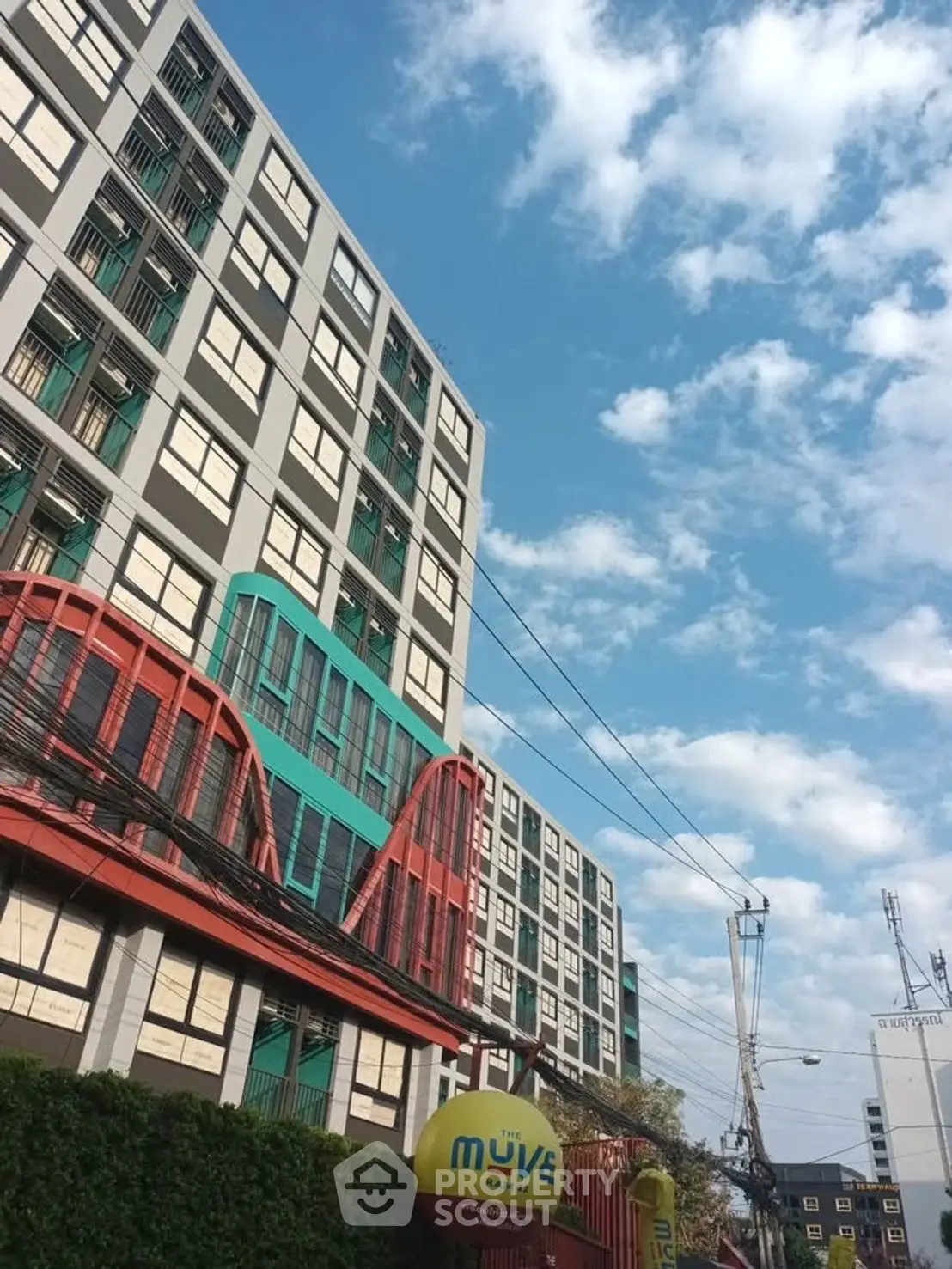 Modern urban apartment building with colorful facade under a clear blue sky.