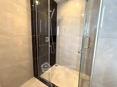 Modern bathroom with sleek glass shower enclosure and elegant tile design.