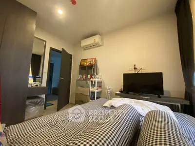 Cozy bedroom with modern decor and air conditioning, featuring a TV and stylish furniture.