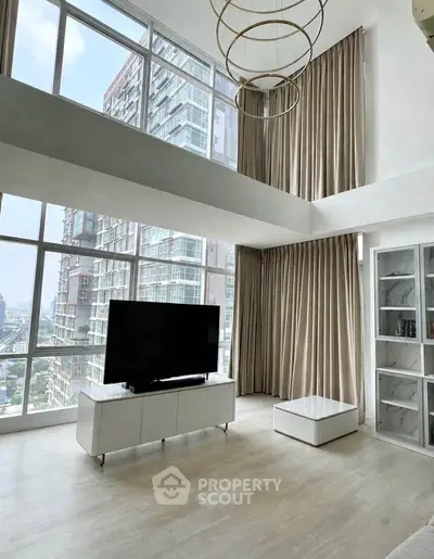 Luxurious high-ceiling living room with floor-to-ceiling windows and modern decor in a high-rise apartment.