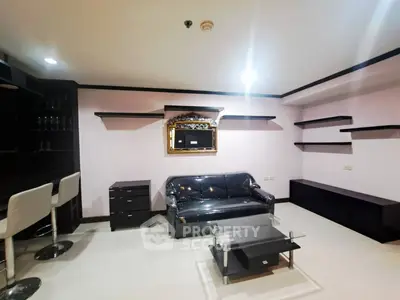 Modern living room with sleek black furniture and stylish shelving
