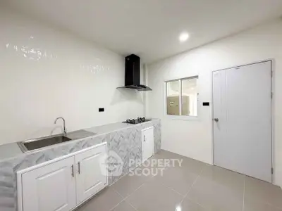 Modern kitchen with sleek design, featuring gas stove and ample storage space.