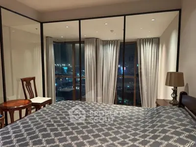 Luxurious bedroom with floor-to-ceiling windows offering stunning city views at night.