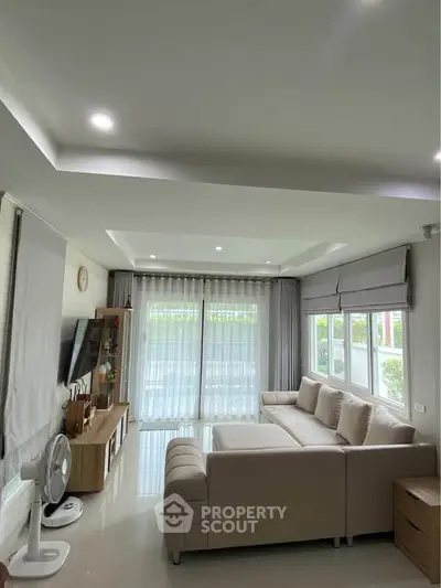 Spacious living room with modern decor and large windows for natural light.