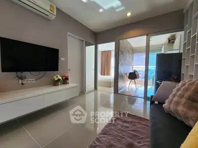 Modern living room with sleek design, wall-mounted TV, and access to a bright balcony.