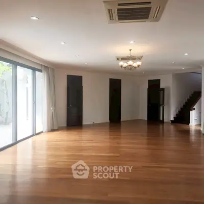 Spacious living room with wooden flooring and elegant lighting