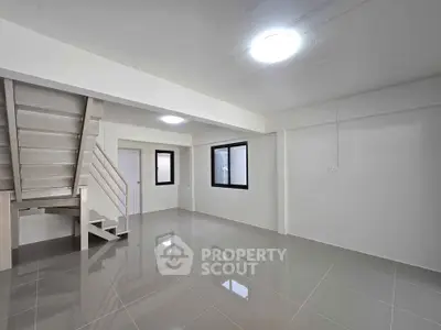 Spacious modern interior with sleek staircase and glossy tiled flooring, perfect for customization.