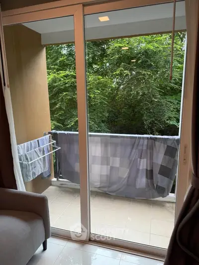 Cozy balcony view with lush greenery, perfect for relaxation and fresh air.