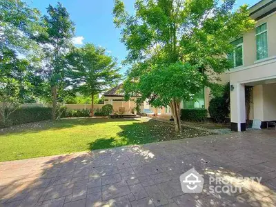 Spacious garden with lush greenery and paved patio in a beautiful residential property.