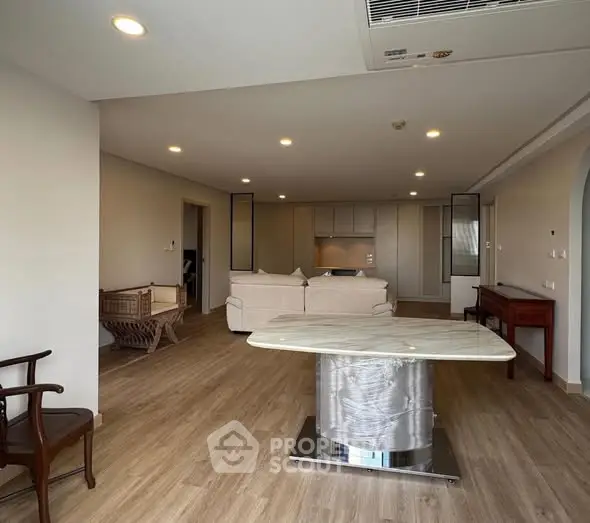 Spacious open-plan living room with modern furniture and wooden flooring, ideal for contemporary living.