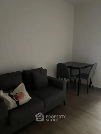 Cozy living room with modern gray sofa and small dining table set