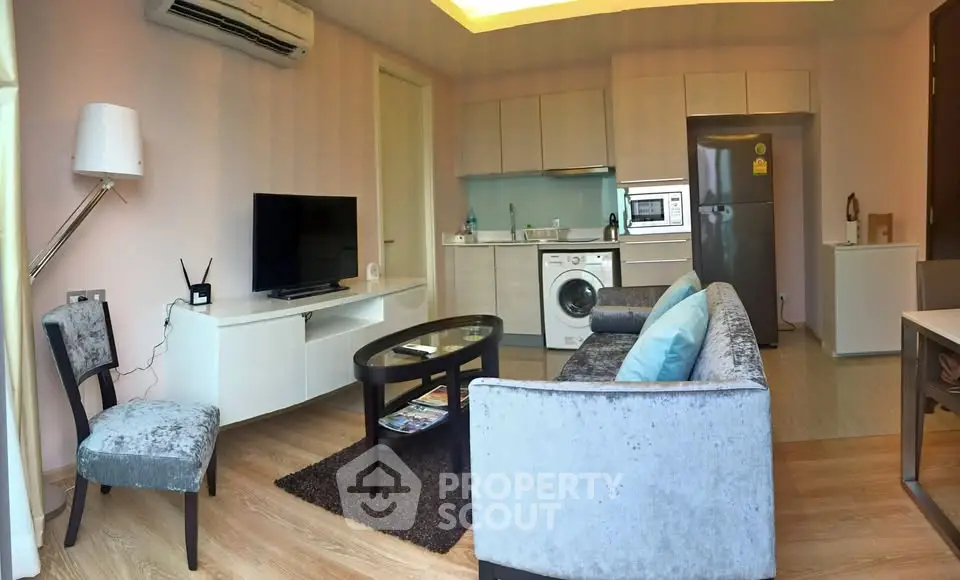 Modern living room with stylish furniture and integrated kitchen appliances in a cozy apartment.