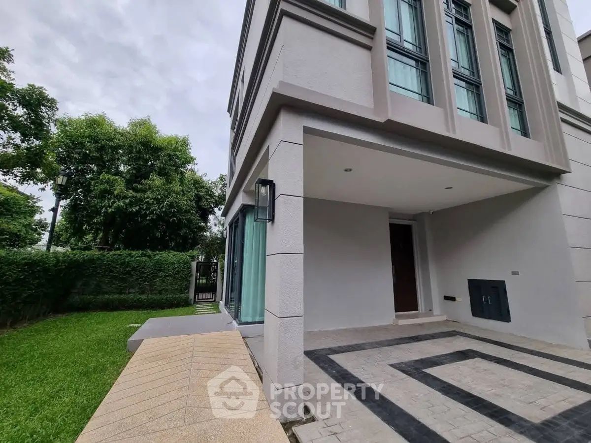 Modern townhouse exterior with lush green garden and stylish entrance