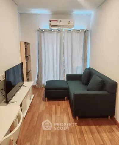 Cozy living room with modern sofa and TV setup, perfect for relaxation.