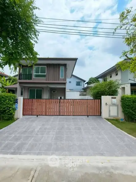 Modern two-story house with spacious driveway and lush greenery, perfect for family living.