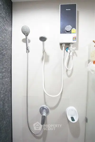 Modern bathroom shower with dual showerheads and sleek water heater.