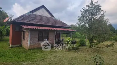 Charming rustic brick house with lush garden and serene countryside setting.