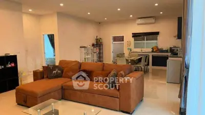 Spacious open-plan living room with modern kitchen and cozy sectional sofa.